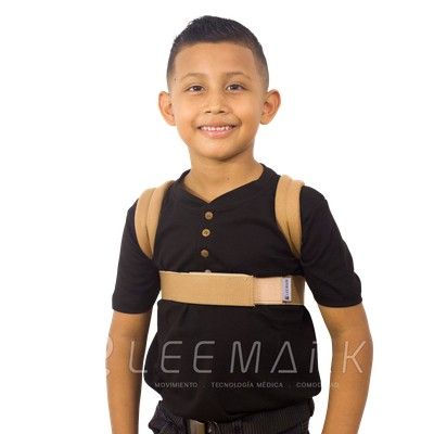 Niño sonriente con camiseta negra y mochila de color canela, de pie sobre un fondo blanco.