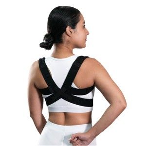 Mujer con un corrector postural negro y beige, vista de espaldas sobre un fondo blanco.