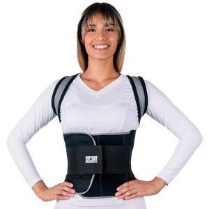 Mujer con un corsé negro sobre una camisa blanca, de pie con las manos en las caderas sobre un fondo blanco.