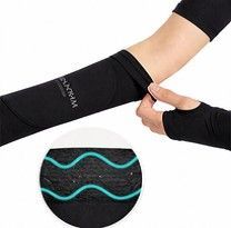 Persona que lleva mangas negras con agujeros para los pulgares y un conjunto deportivo blanco.