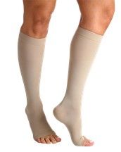 Dos piernas con medias de compresión color beige hasta la rodilla; un pie se muestra de perfil y el otro desde atrás.