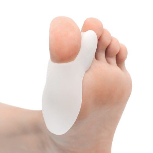 Separador de dedos de silicona blanca sobre un pie descalzo, manteniendo el dedo gordo separado de los demás.