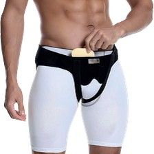 Persona que lleva una faja de soporte inguinal en blanco y negro, ajustándose una bolsa frontal.