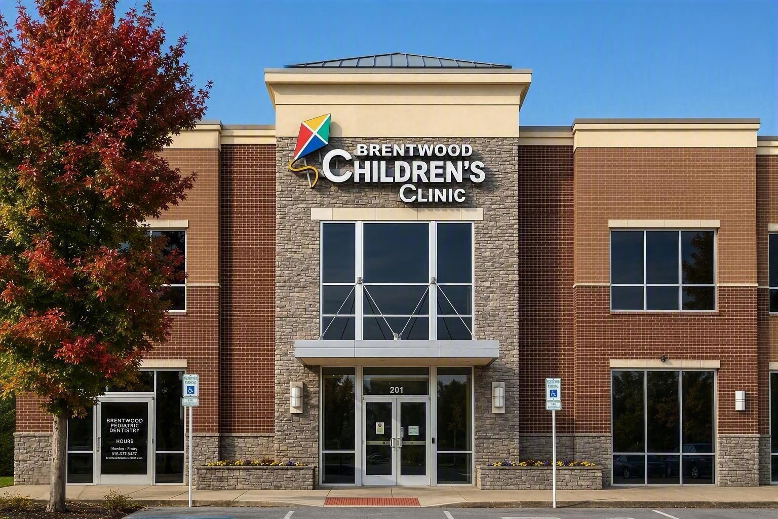 Exterior of Brentwood Children’s Clinic with brick facade and a red-leaved tree on the left