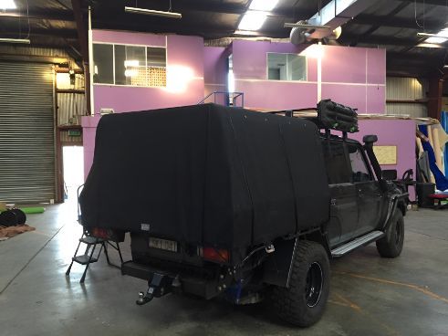 A Black Truck Is Parked In A Warehouse — Western Tarps and Motor Trimming In Dubbo, NSW