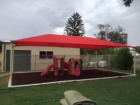 A Playground With A Red Shade Sail Over It — Western Tarps and Motor Trimming In Dubbo, NSW