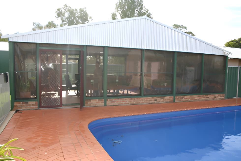A Screened In Area With A Swimming Pool In Front Of It — Western Tarps and Motor Trimming In Dubbo, NSW