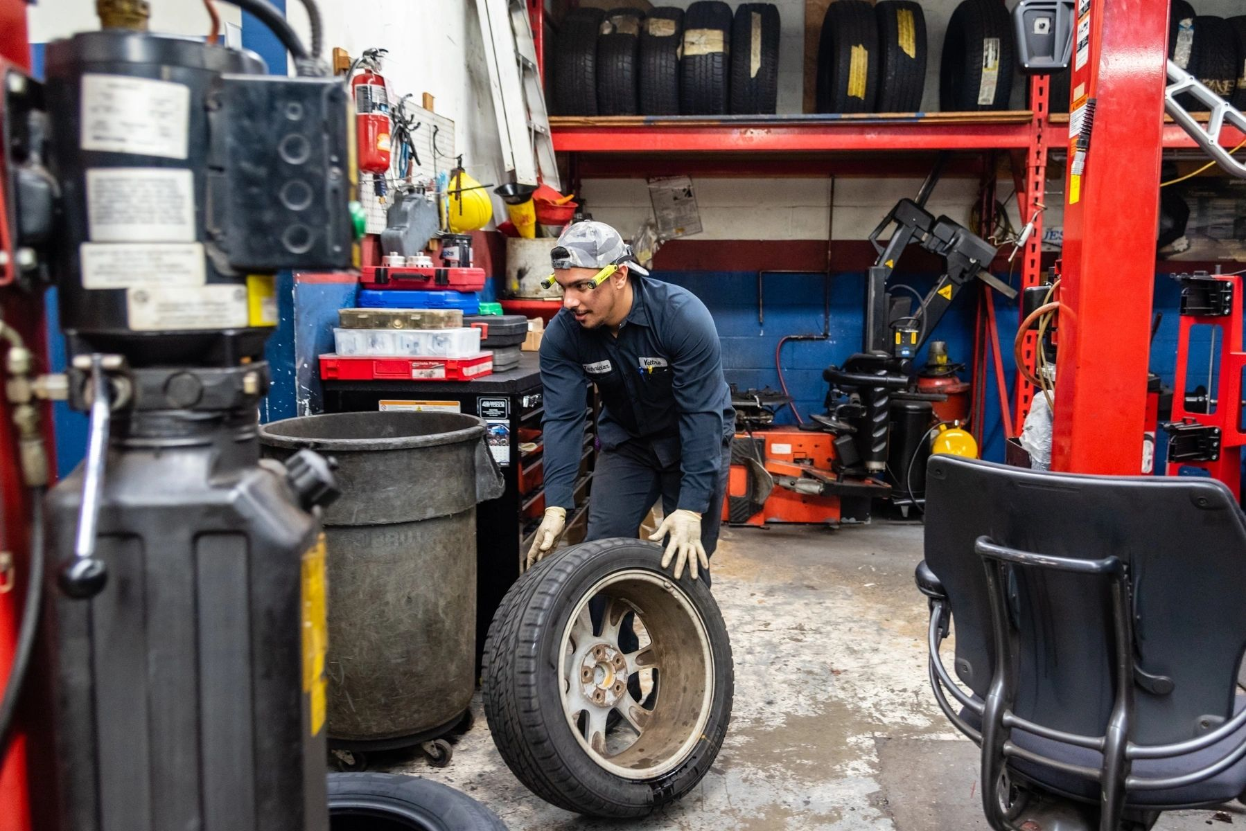 A man is changing a tire in a tire shop. | Van Dorn Auto Repair
