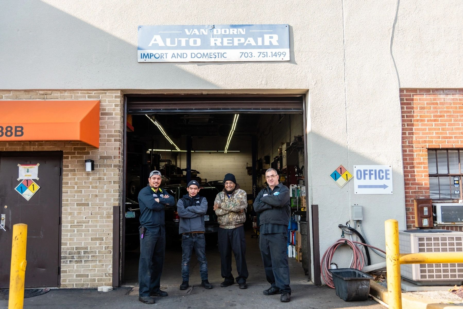 A group of men are standing in front of an auto repair shop. | Van Dorn Auto Repair
