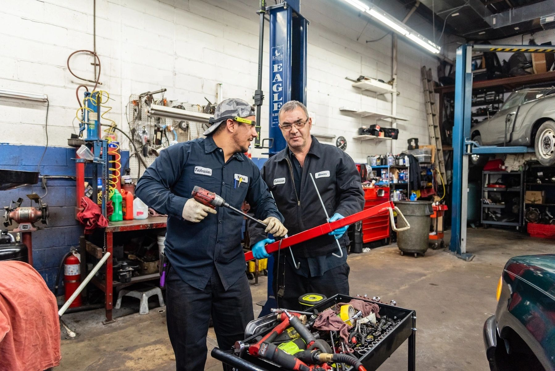 Two mechanics are working on a car in a garage. | Van Dorn Auto Repair