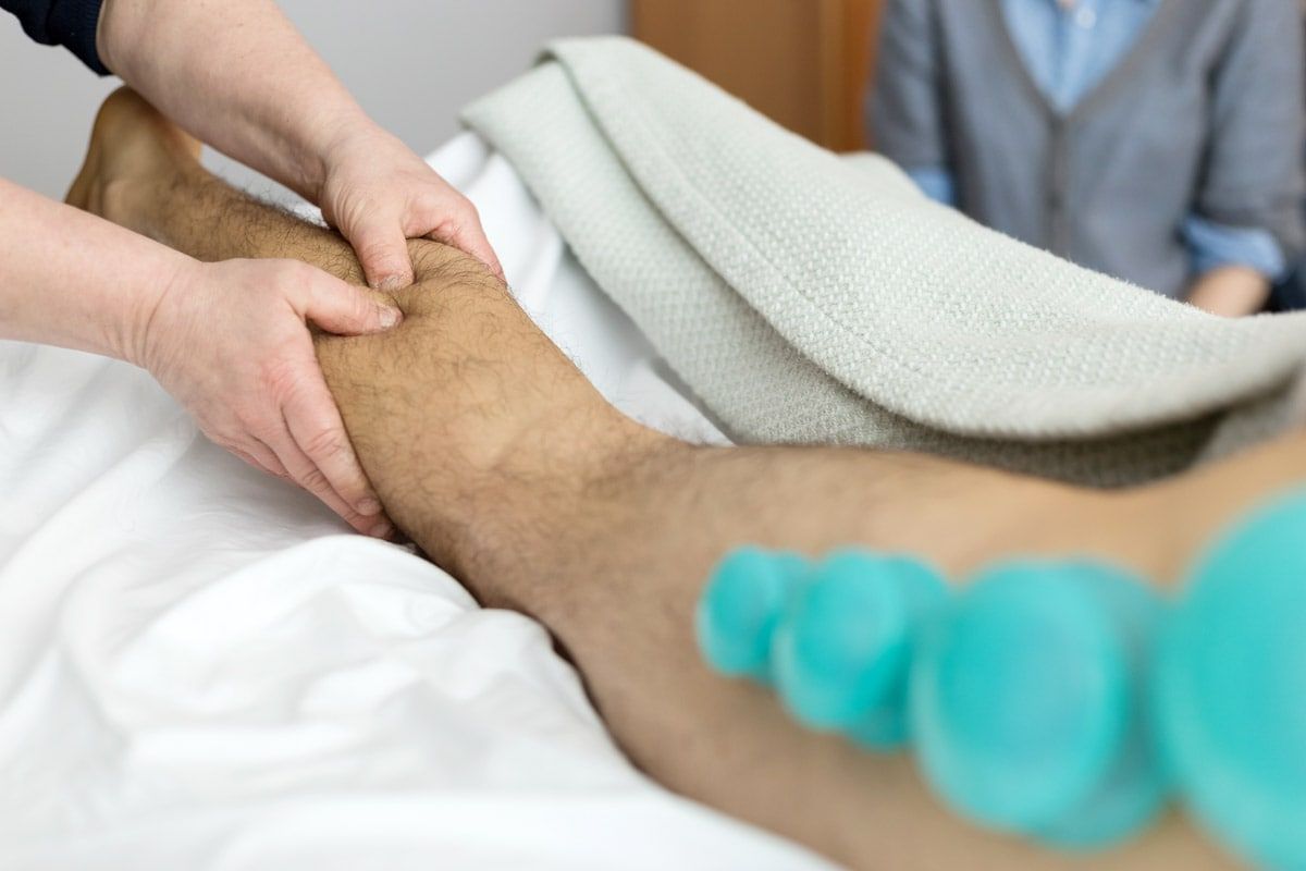 A person is giving a man a massage on his leg