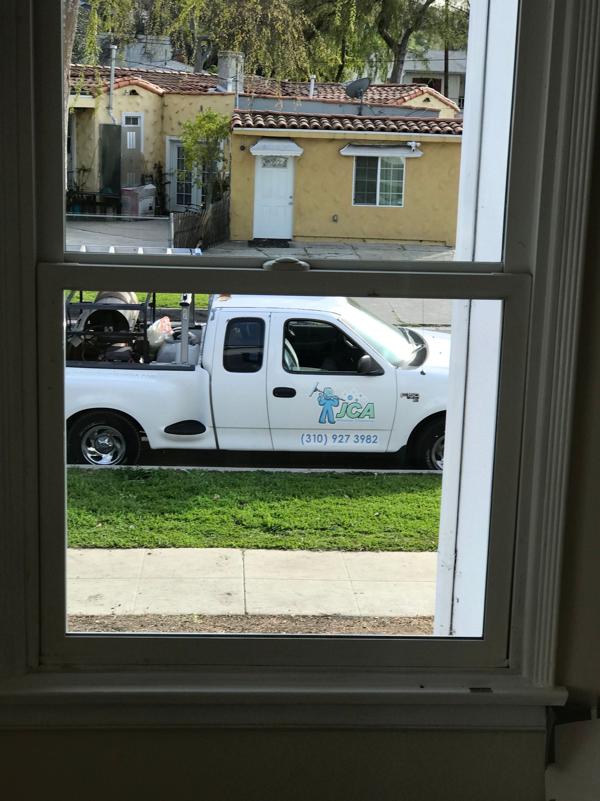 jca window cleaning truck is parked in front of a house