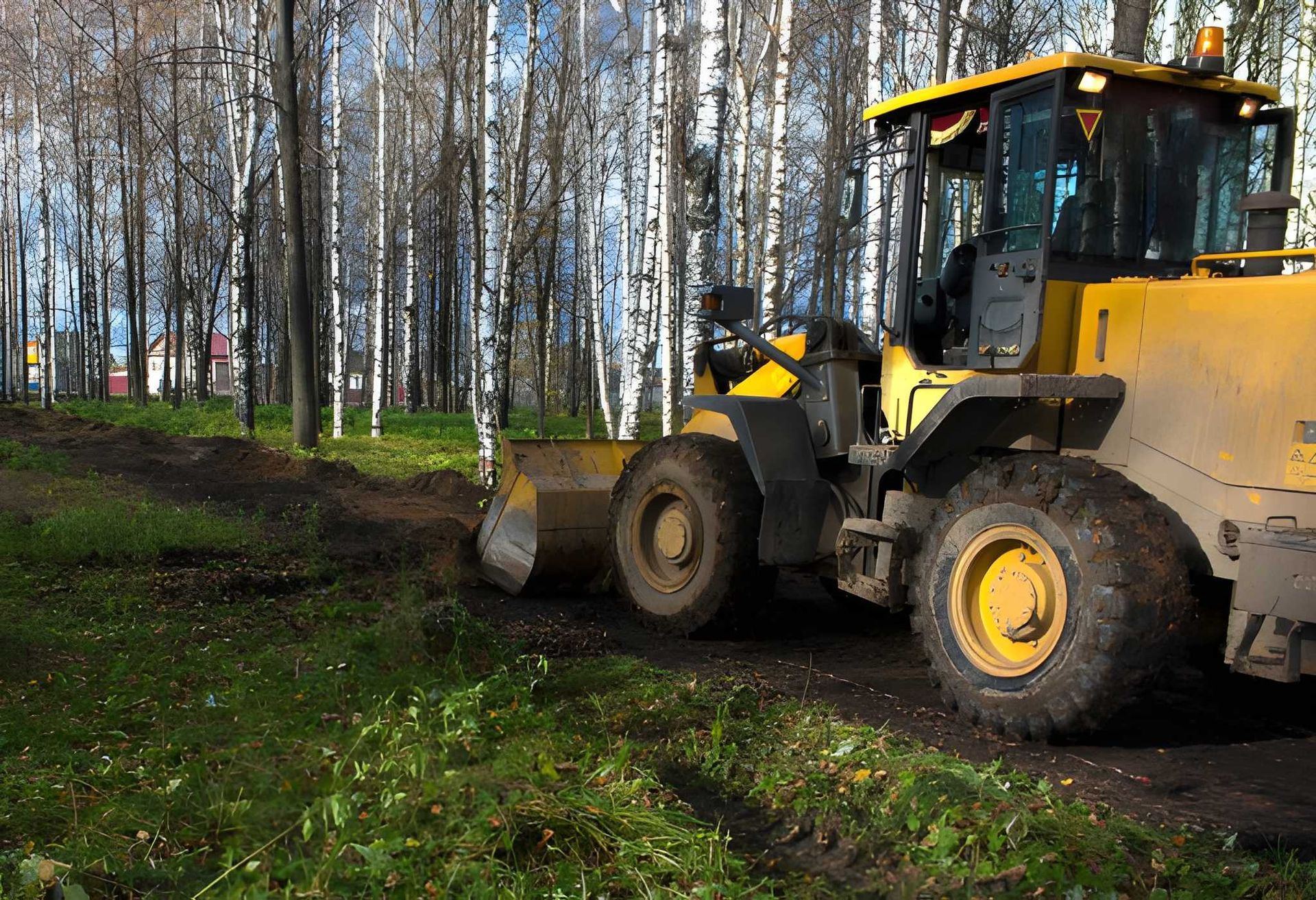 Yellow Wheel Loader Clearing Muddy Ground — A & S Cuthel Earthmoving & Transport in Armidale, NSW