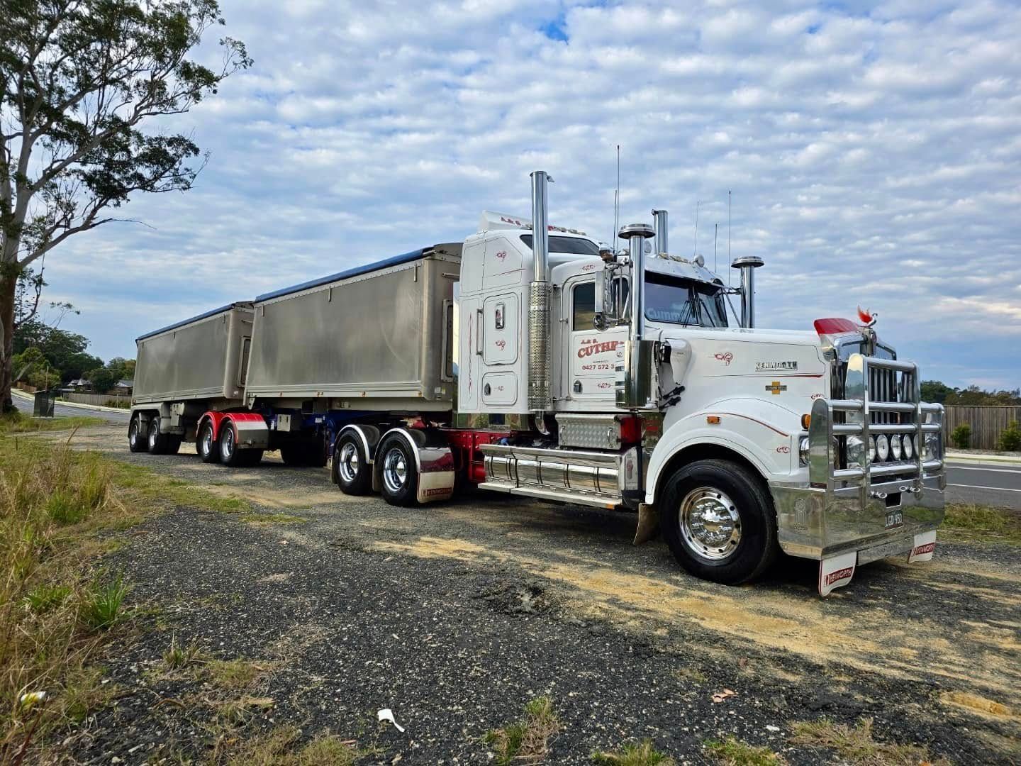 White Semi Truck with A Long Trailer Parked on A Gravel Lot — A & S Cuthel Earthmoving & Transport in Dorrigo, NSW