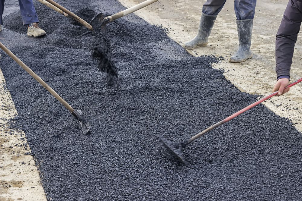 Workers Spreading Fresh Black Asphalt — A & S Cuthel Earthmoving & Transport in Coffs Harbour, NSW