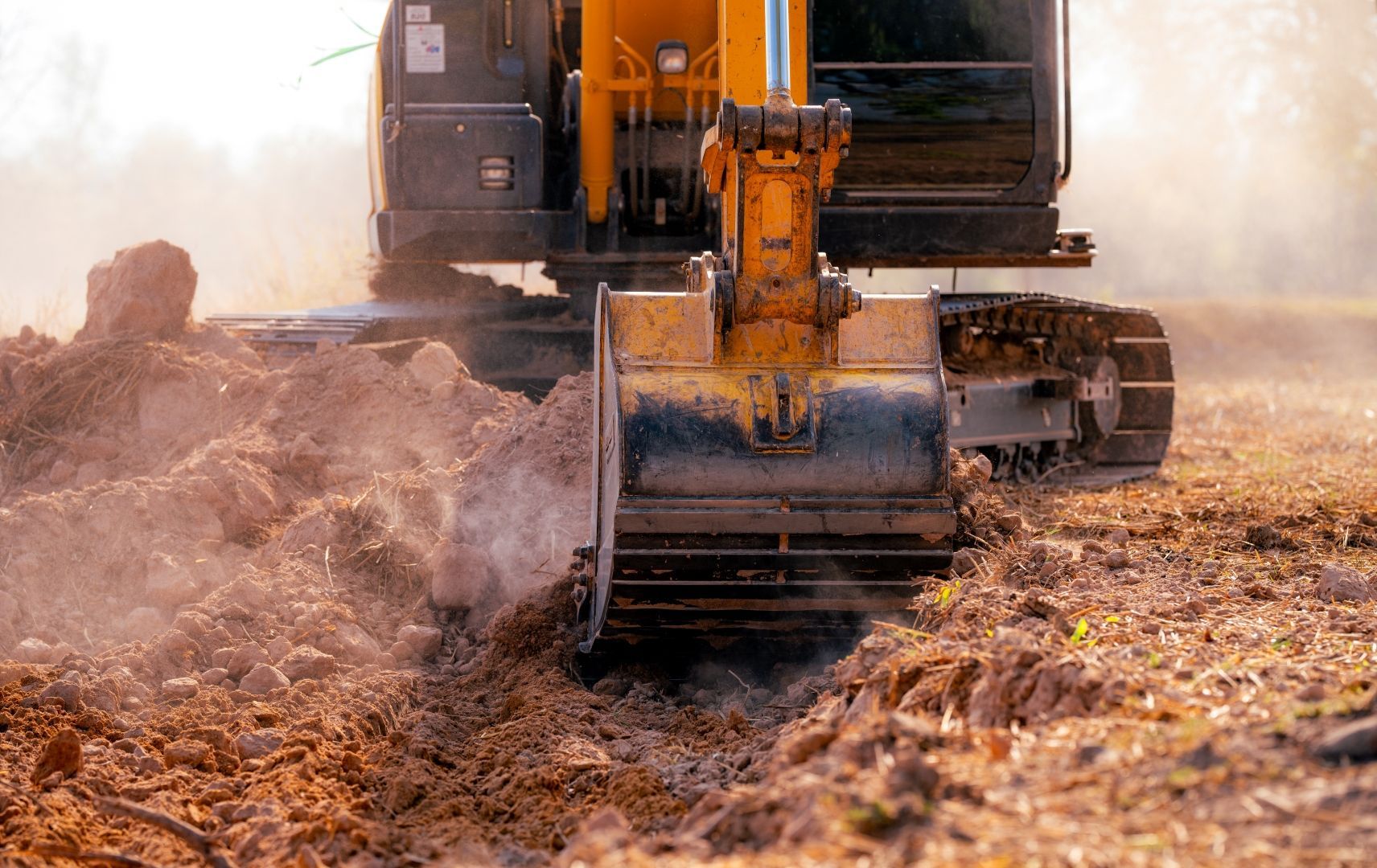 Yellow Excavator Clearing Dry Dirt — A & S Cuthel Earthmoving & Transport in Armidale, NSW