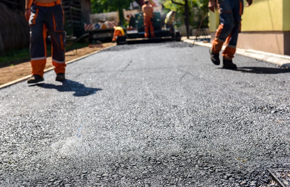 Workers Paving a Road With Fresh Asphalt — A & S Cuthel Earthmoving & Transport in Bellingen, NSW
