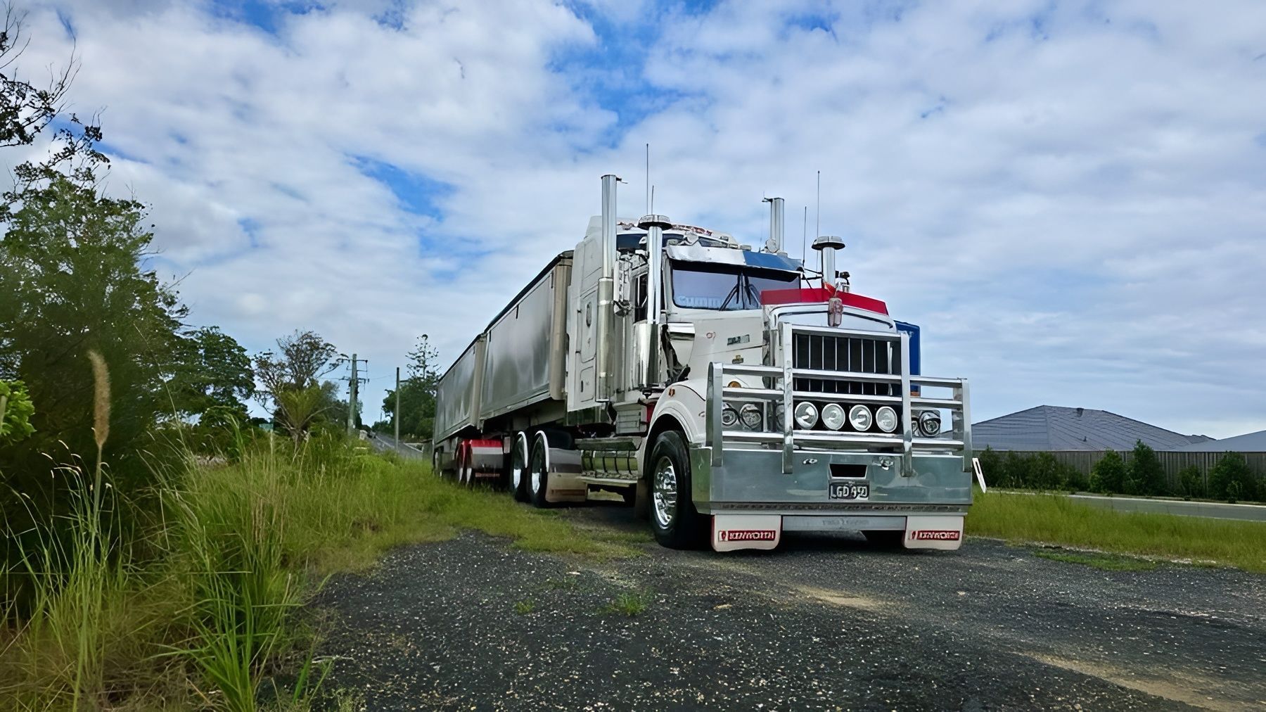 White Semi Truck Hauling a Trailer on A Rural Gravel Road Under a Cloudy Sky — A & S Cuthel Earthmoving & Transport in Nambucca Heads, NSW