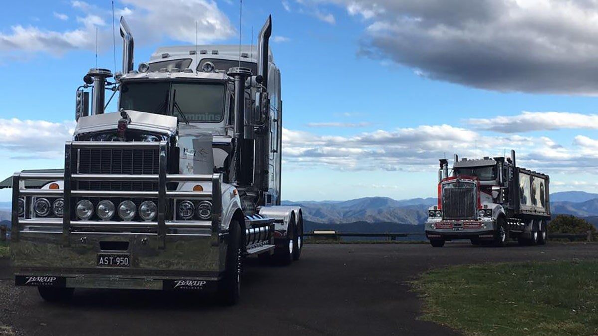 Two Large Trucks on a Paved Lot — A & S Cuthel Earthmoving & Transport in Dorrigo, NSW