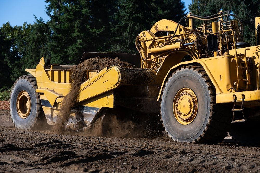 Yellow Earthmover Grading Dirt — A & S Cuthel Earthmoving & Transport in Armidale, NSW