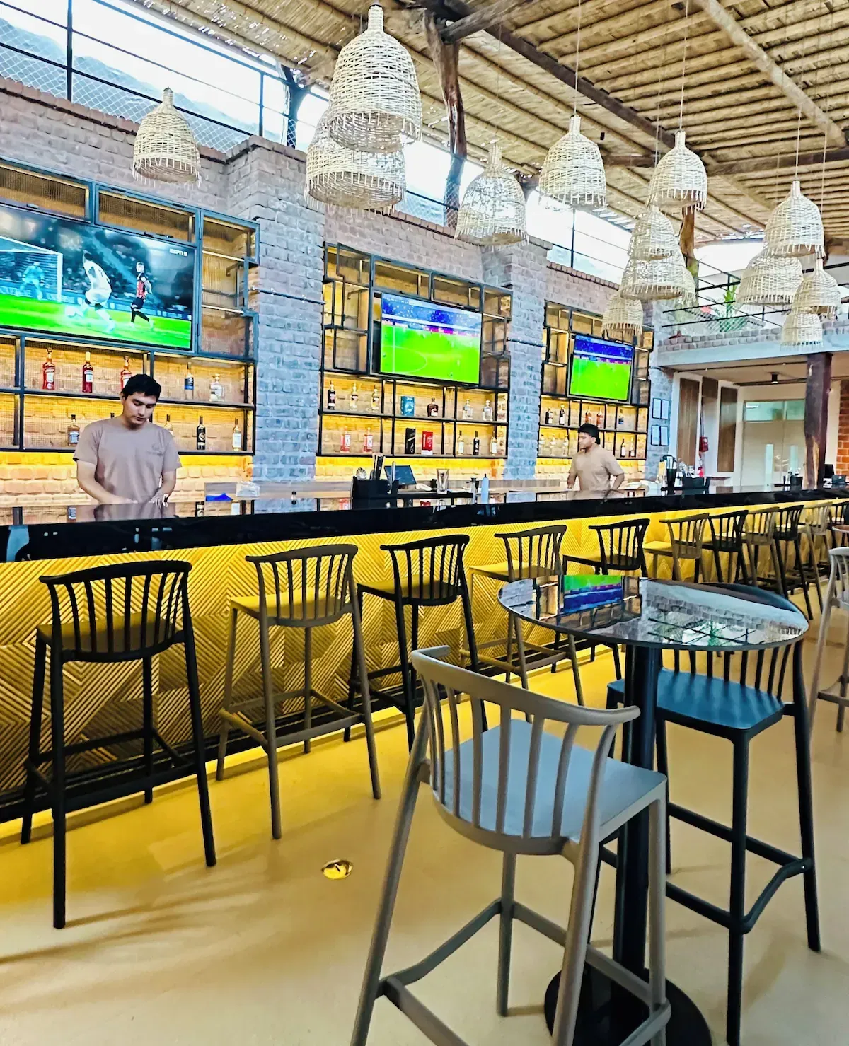 A man is standing at a bar in a restaurant.