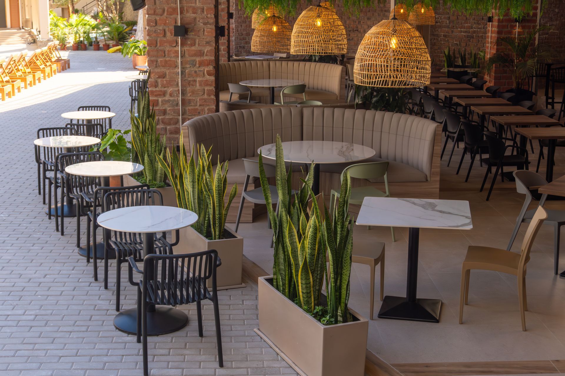 A restaurant with tables and chairs and a brick wall.