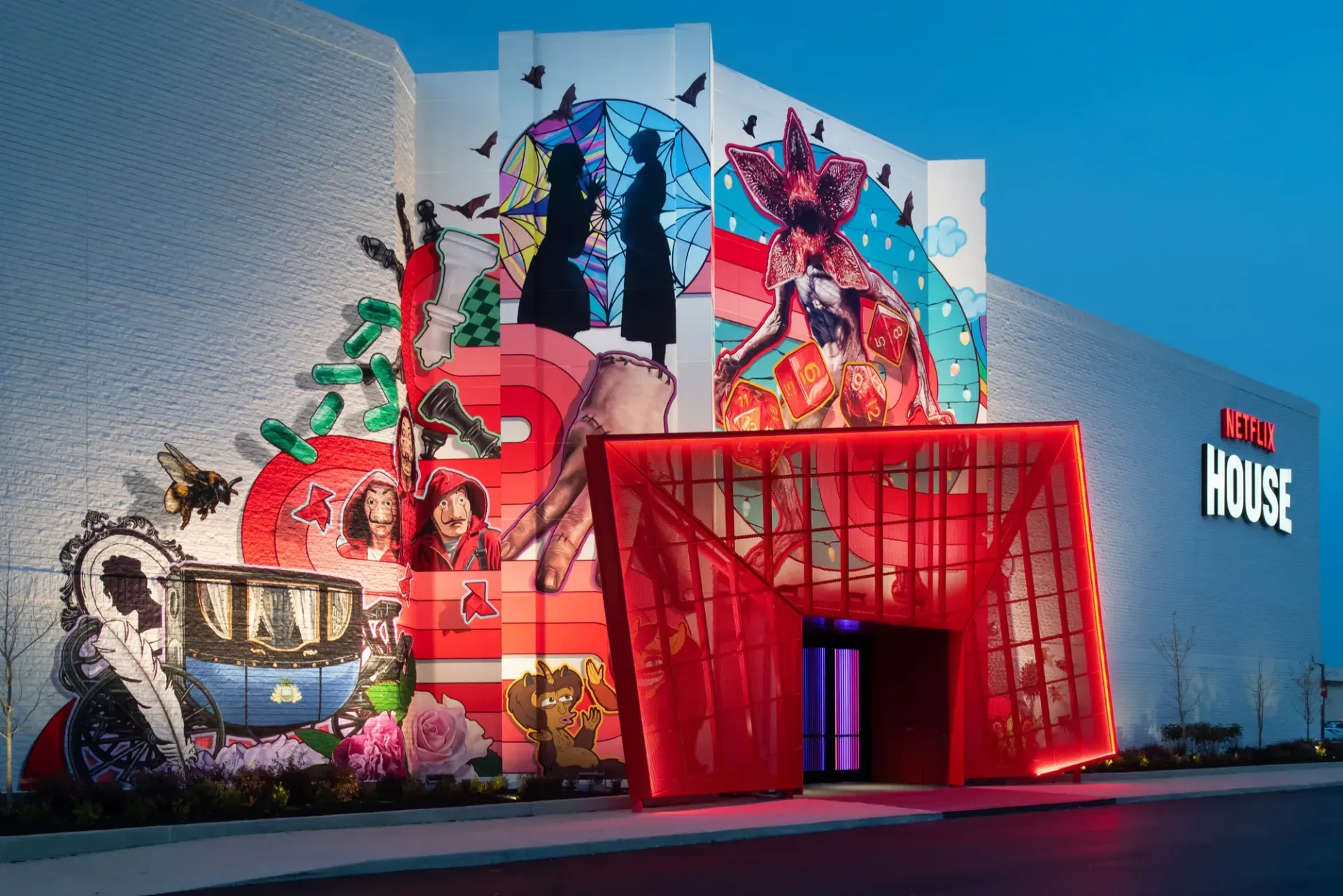 A Netflix House building with a vibrant, character-filled mural and a striking, bright red geometric entryway.