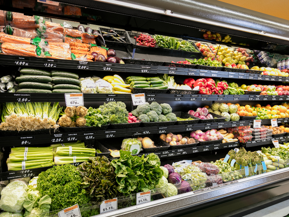 A grocery store aisle filled with lots of fruits and vegetables.