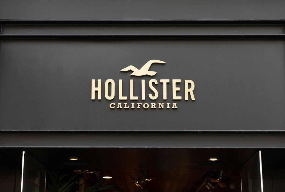 The Hollister California logo featuring a stylized seagull in gold lettering on a dark gray store exterior.