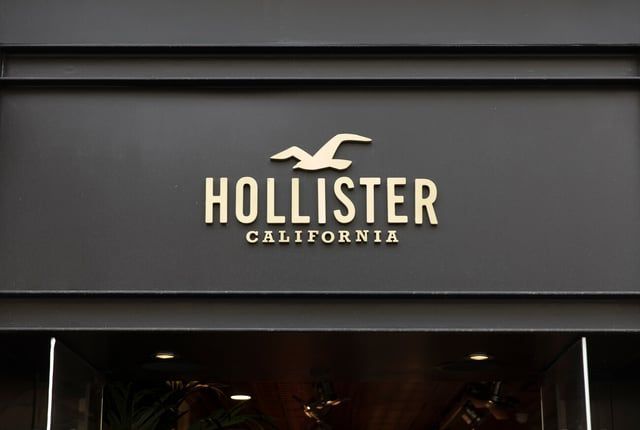 A cream-colored Hollister California logo centered on a dark grey storefront sign.