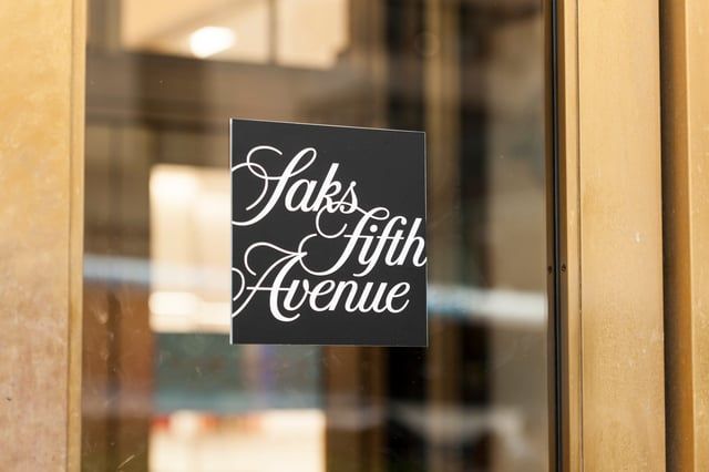 A square black sign with the white cursive 