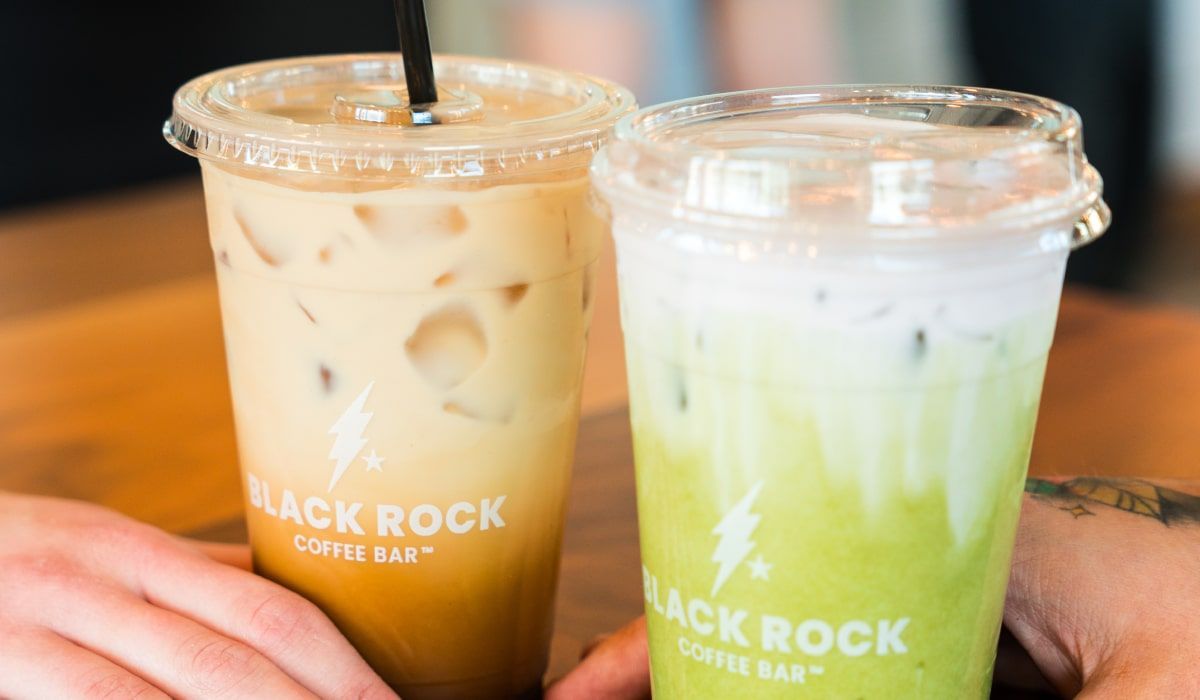 Two iced drinks from Black Rock Coffee Bar—one coffee and one matcha—being held by two people.