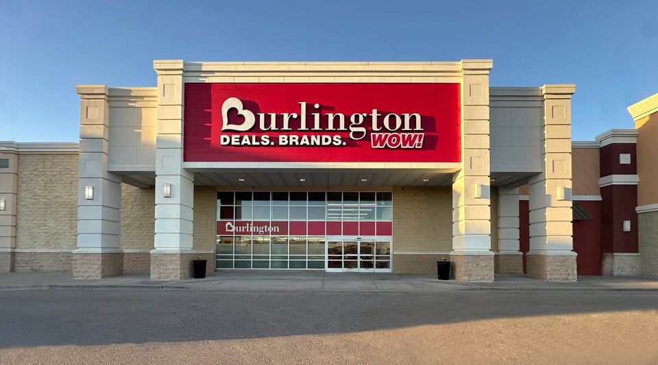 Exterior view of a Burlington retail store featuring a large red sign with the store name and logo above the entrance.