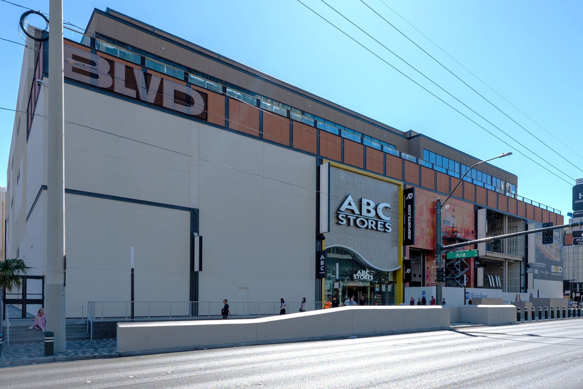 A multi-story commercial building on a sunny street featuring an ABC Store, with “BLVD” signage on the upper exterior.