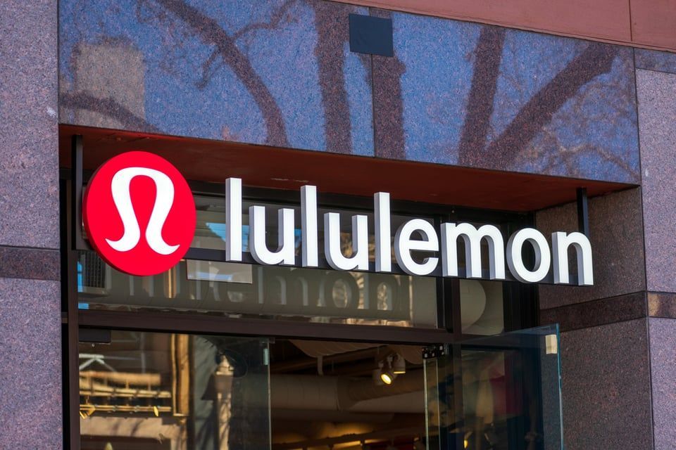 The lululemon logo and storefront sign in white lettering, set against a brown stone facade.