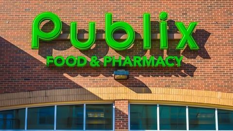 A bright green, 3D Publix sign above a brick exterior, reading 