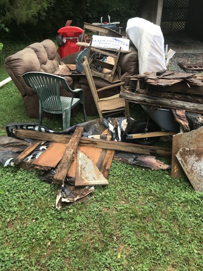 A pile of junk is outside a brick building.