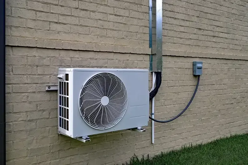 Ductless air conditioner installation on brick wall by HVAC technicians in Hackensack, NJ
