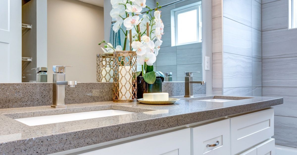 A bathroom counter with flowers placed on it. There is a shower to the right of the counter.
