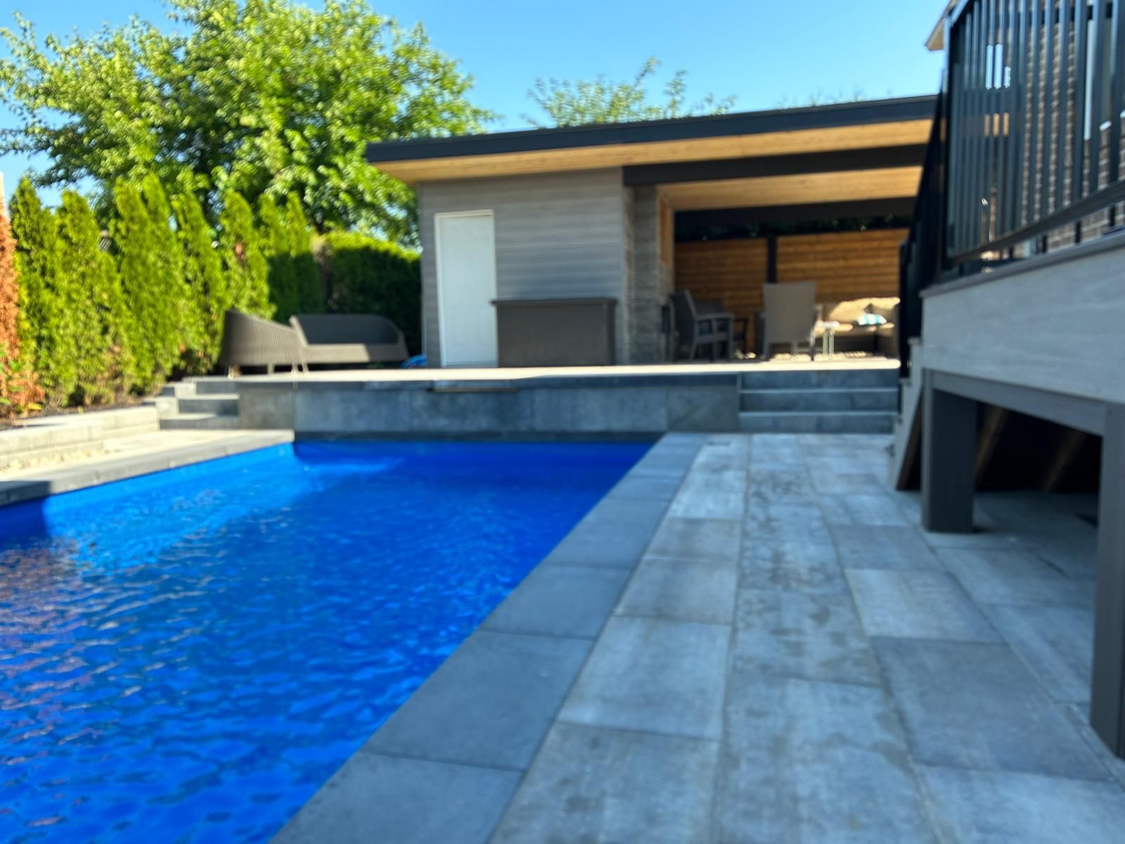 A large swimming pool with a gazebo in the background