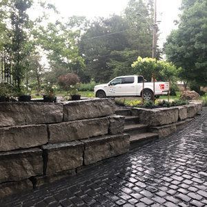 Precast cobble stone driveway with large natural stone retaining wall