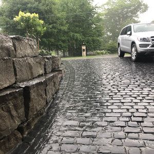 Precast cobble stone driveway with large natural stone retaining wall