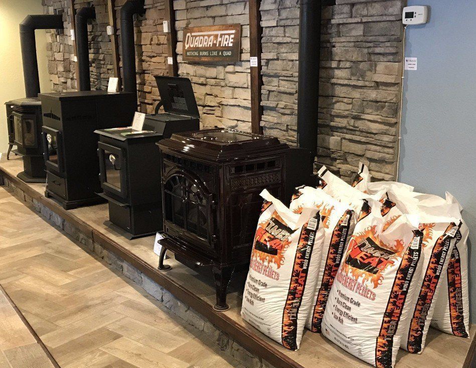 A display of wood stoves and bags of charcoal in a store.