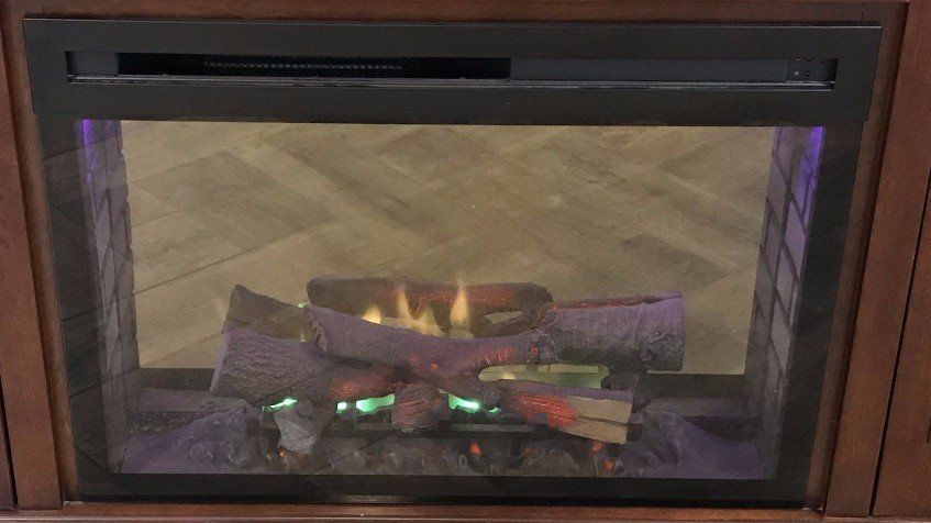 A fireplace with a lot of logs in it and a lot of flames coming out of it.