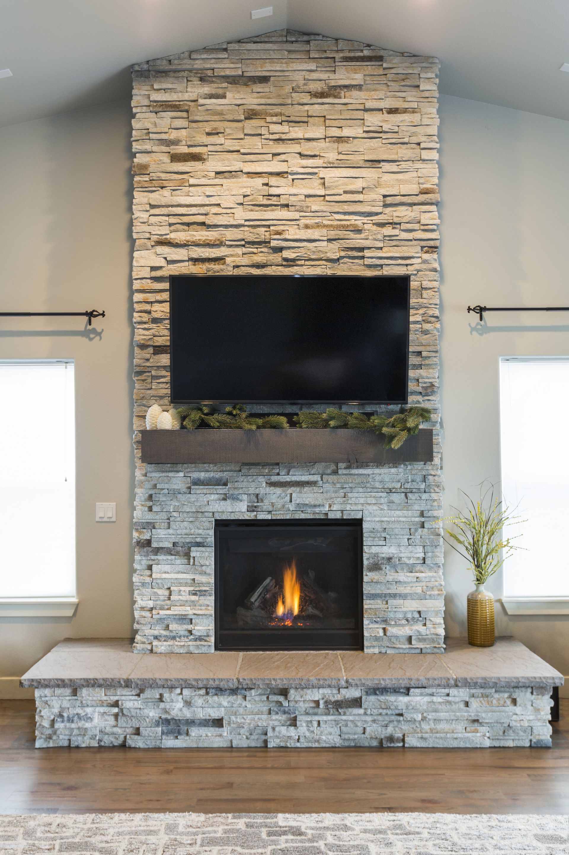A living room with a fireplace and a flat screen tv on the wall.