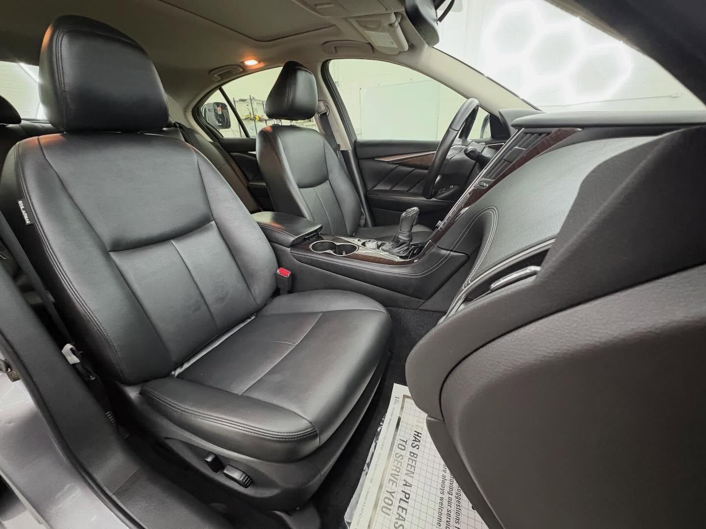 Interior view of a car, showing clean black leather front seats, a center console, and a dashboard.