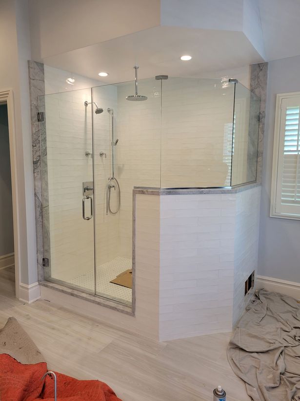 A bathroom with a walk in shower and a window.
