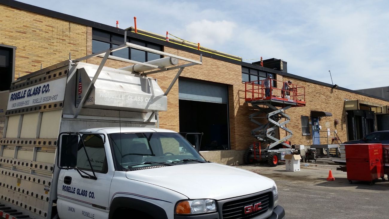 A white truck is parked in front of a brick building