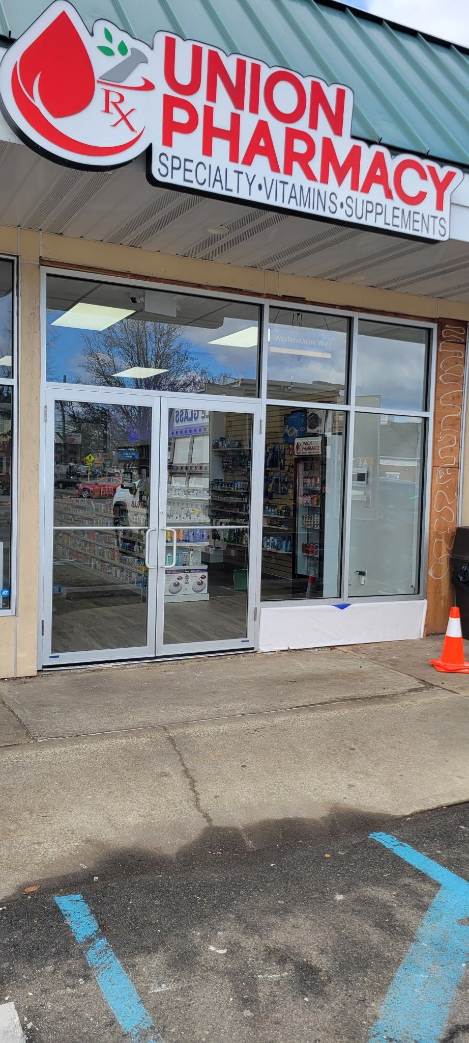 The front of a union pharmacy with a blue parking spot in front of it.