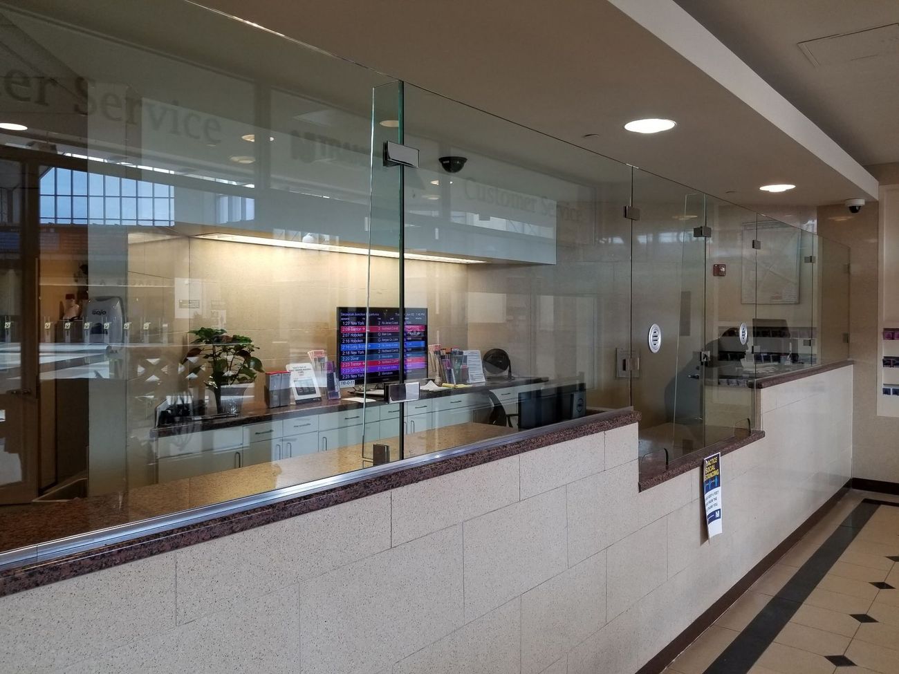 A bank counter with a glass wall and a computer on it